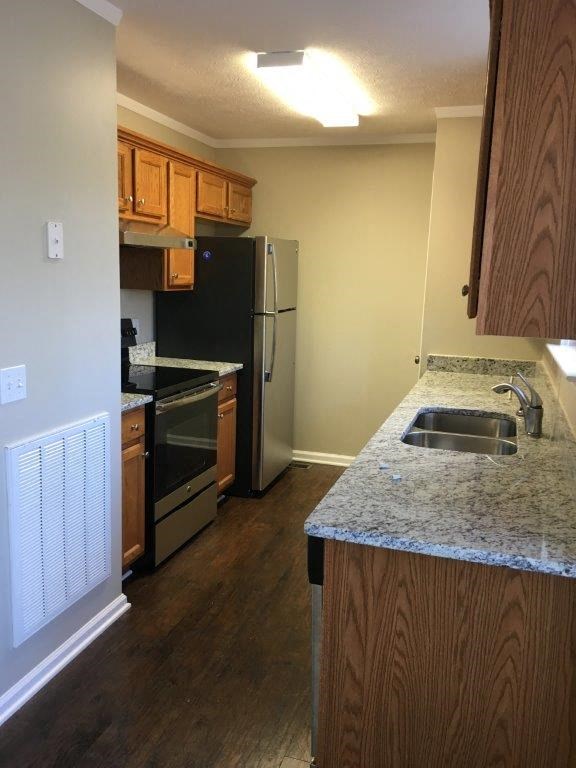 a kitchen with a granite counter top and a refrigerator