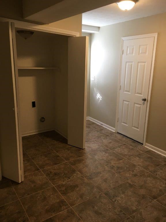 a empty room with a closet and a white door