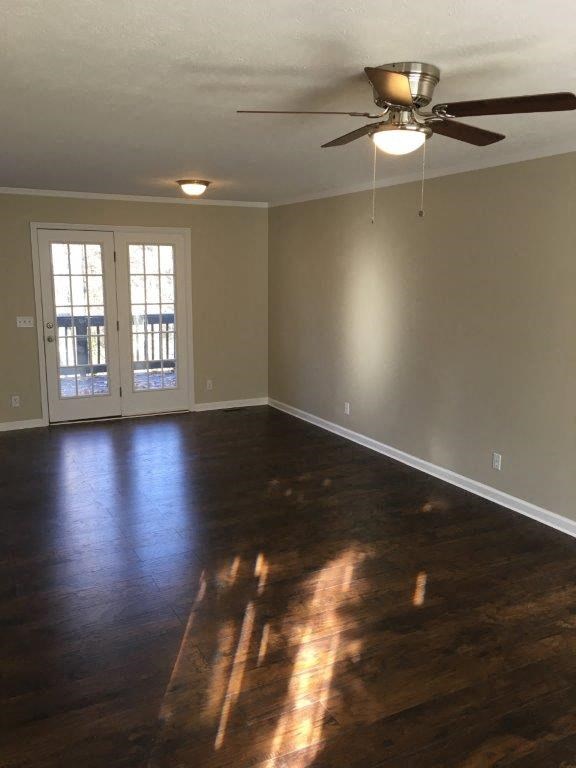 a living room with wood floors and a ceiling fan