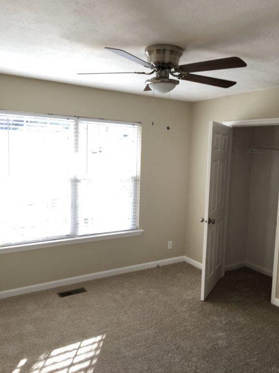 a bedroom with a ceiling fan and a window