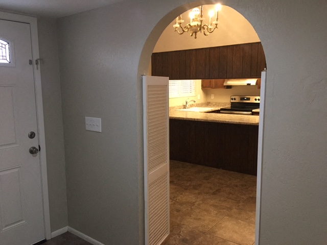 an arched doorway leading into a kitchen with a sink and
