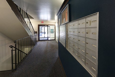 a hallway with a row of lockers and a staircase