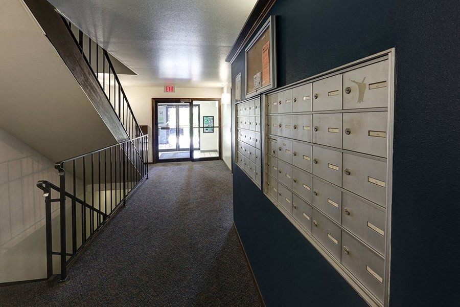 a hallway with a row of lockers and a staircase