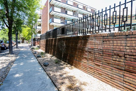 a brick wall with black railings in front of a building