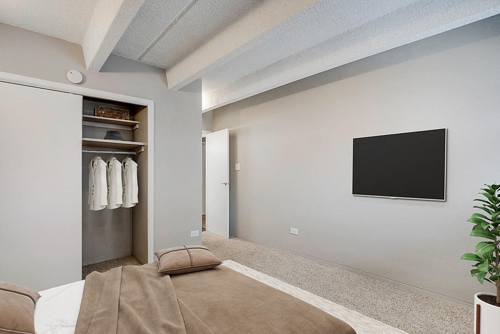 a bedroom with a bed and a television on the wall