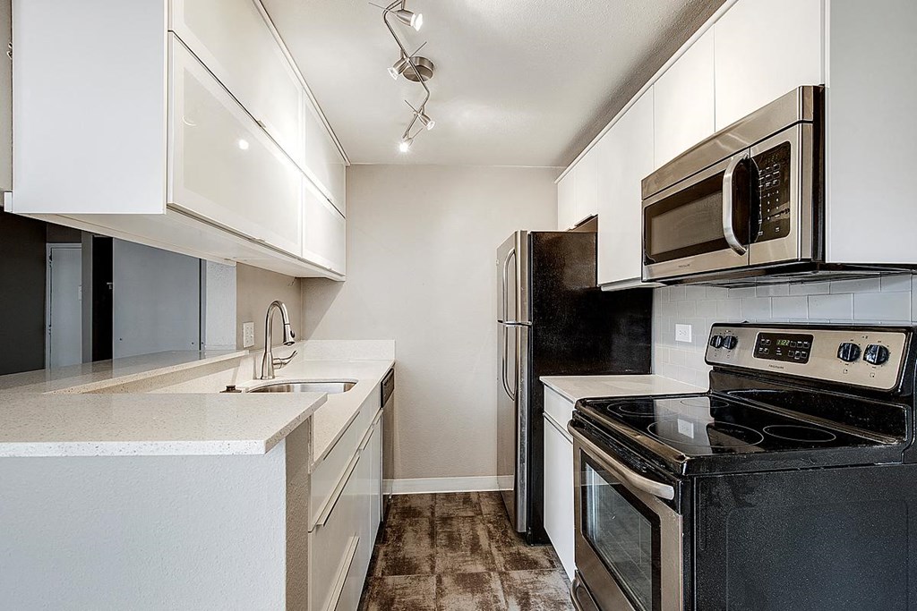 a kitchen with stainless steel appliances and white cabinets
