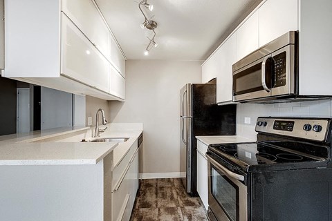 a kitchen with stainless steel appliances and white cabinets