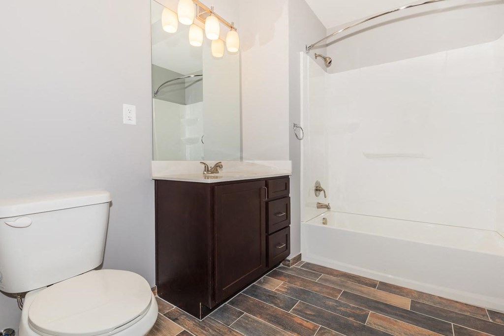a bathroom with a toilet and a tub and a sink