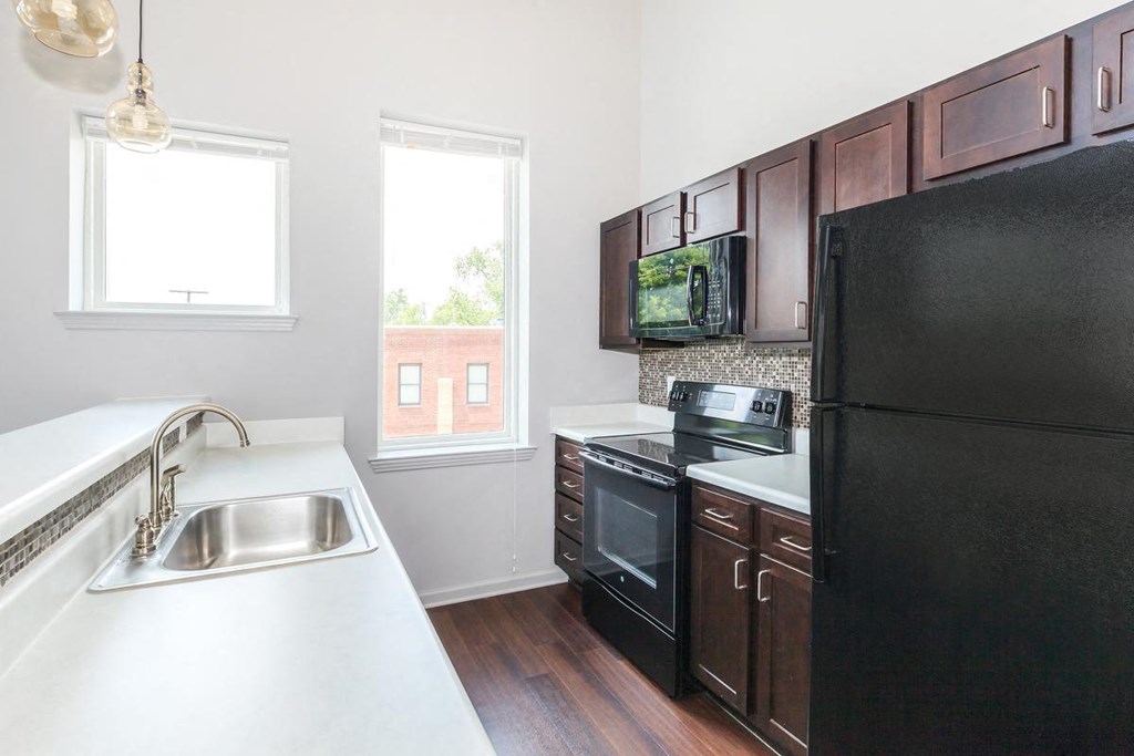 a kitchen with black appliances and white counter tops