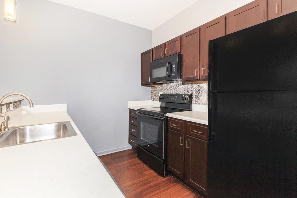 a kitchen with black appliances and white counter tops