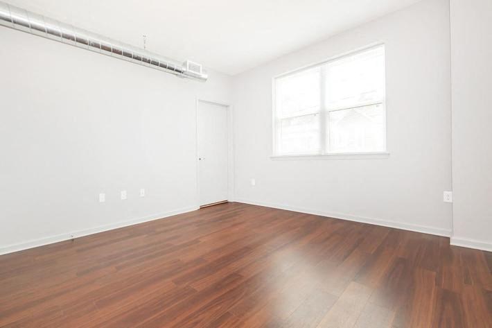an empty room with wood floors and a window