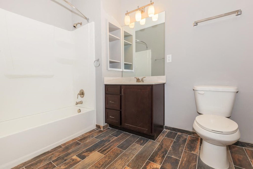 a bathroom with a toilet and a tub and a sink