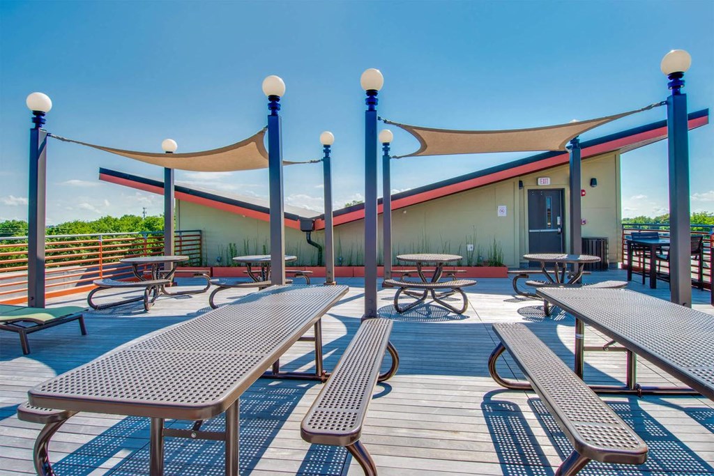a patio with picnic tables and chairs and a building