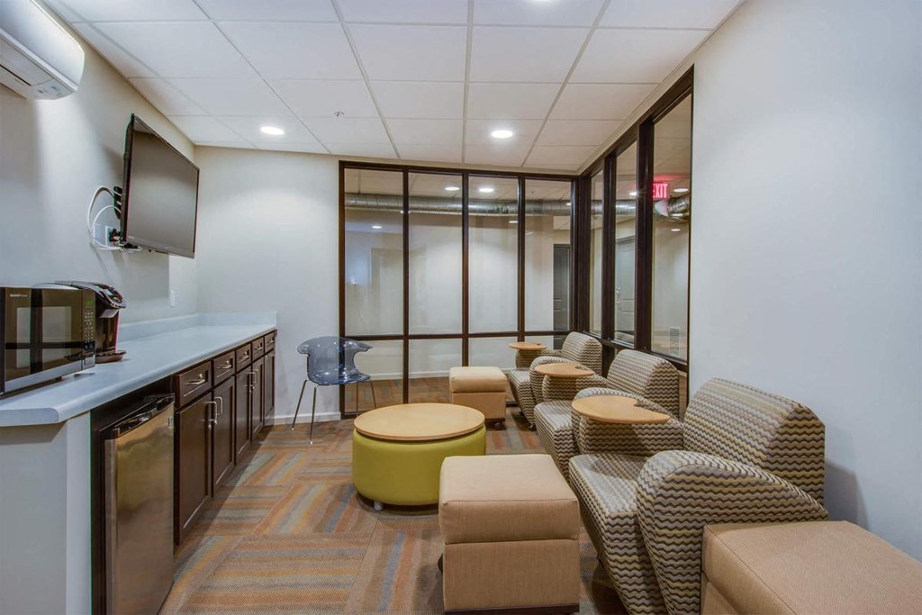 a lounge room with couches and chairs and a television