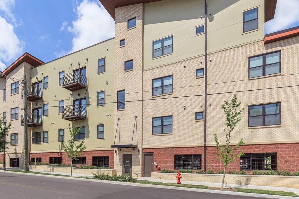 a large brick apartment building with a red fire hydrant