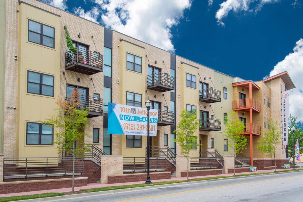 an apartment building with a street sign in front of it