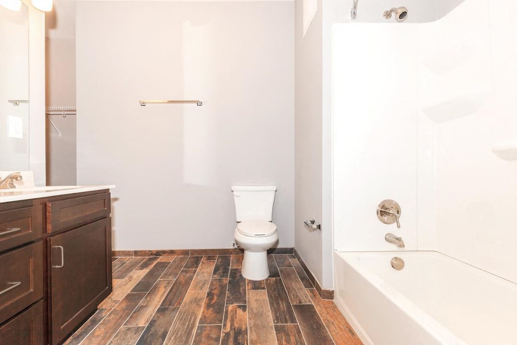 a bathroom with a toilet and a tub and a sink