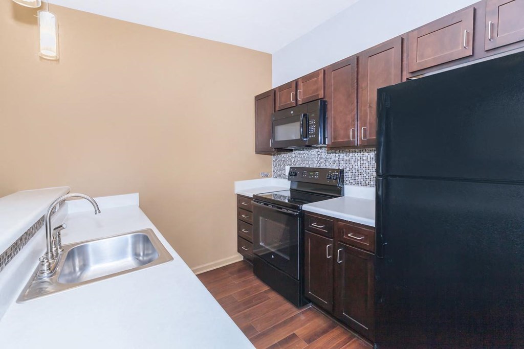 a kitchen with black appliances and white counter tops