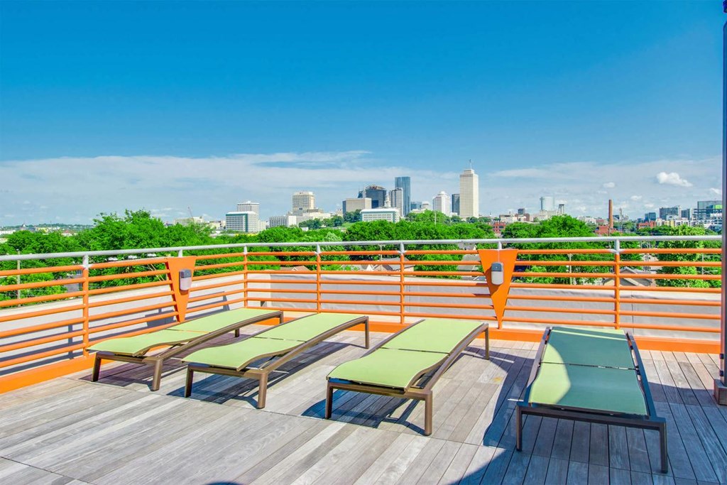 a deck with deck chairs and a view of the city