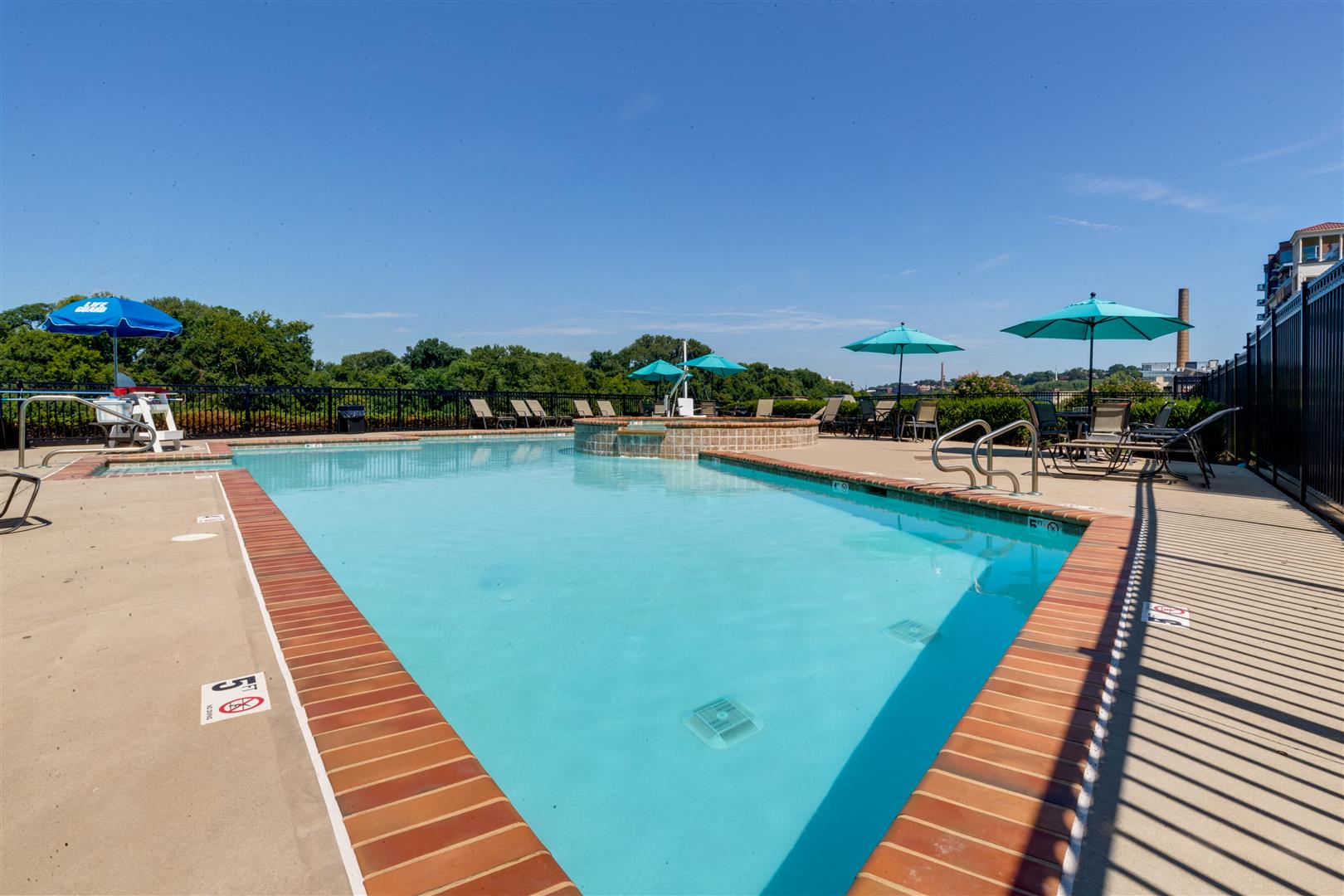 a swimming pool with umbrellas and chairs around it