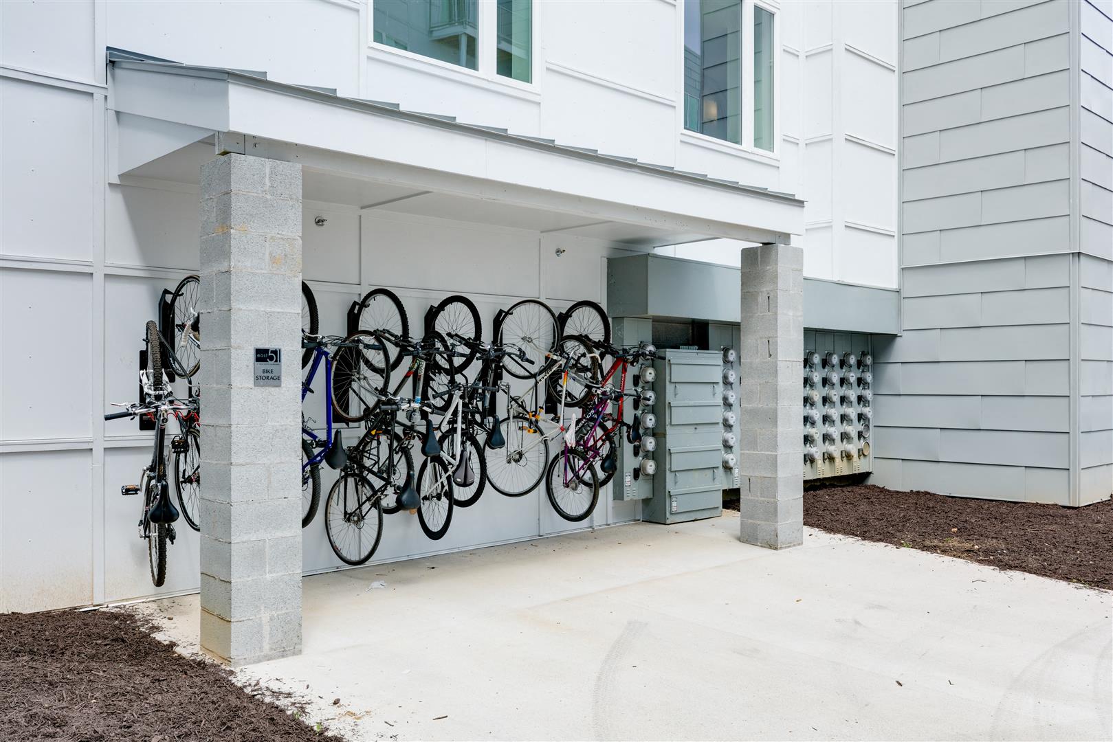a row of bikes hanging on a wall outside of a building