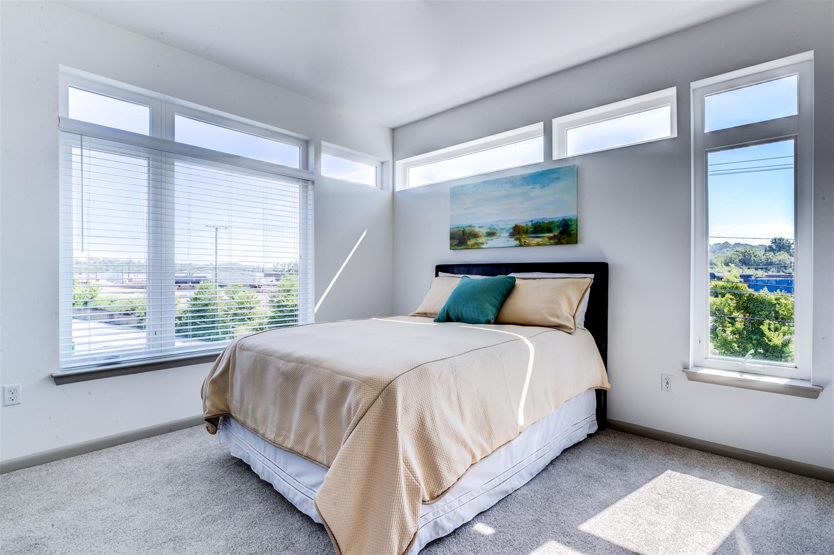 a bedroom with a bed and three windows