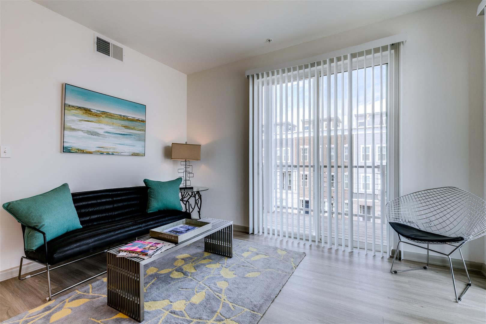 a living room with a couch and a chair and a large window