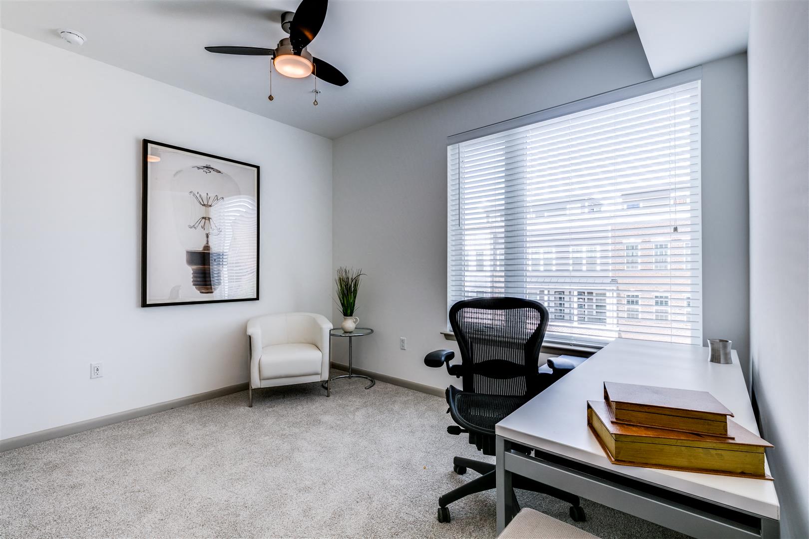 an office with a large window and a desk with a chair