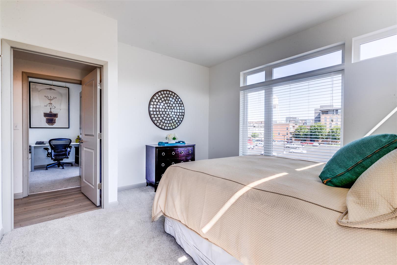 a bedroom with a bed and a door to a office