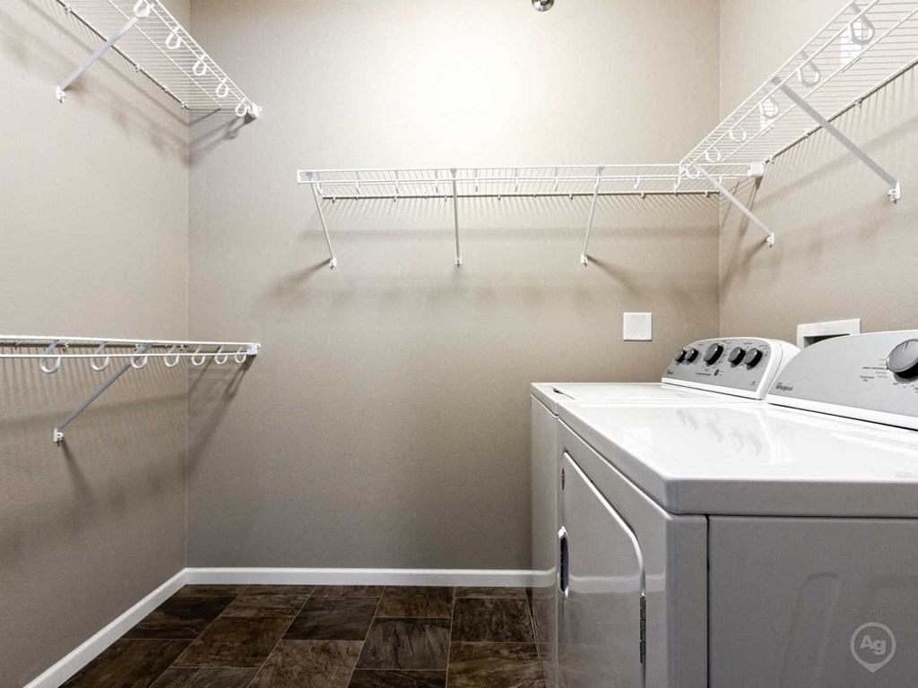 a washer and dryer in a laundry room with shelves and racks