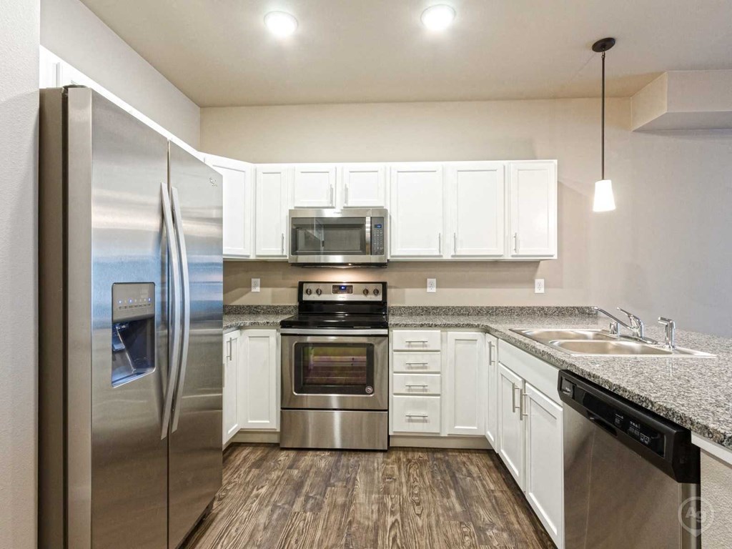 a kitchen with stainless steel appliances and white cabinets