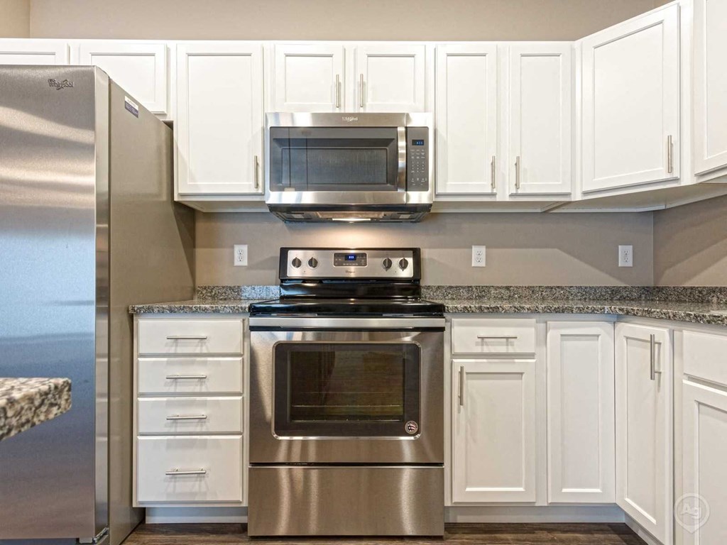 a kitchen with stainless steel appliances and white cabinets