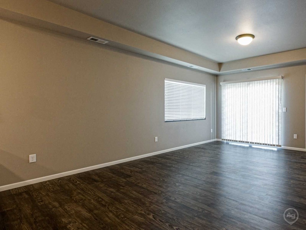 the living room of a new home with wood flooring and a window