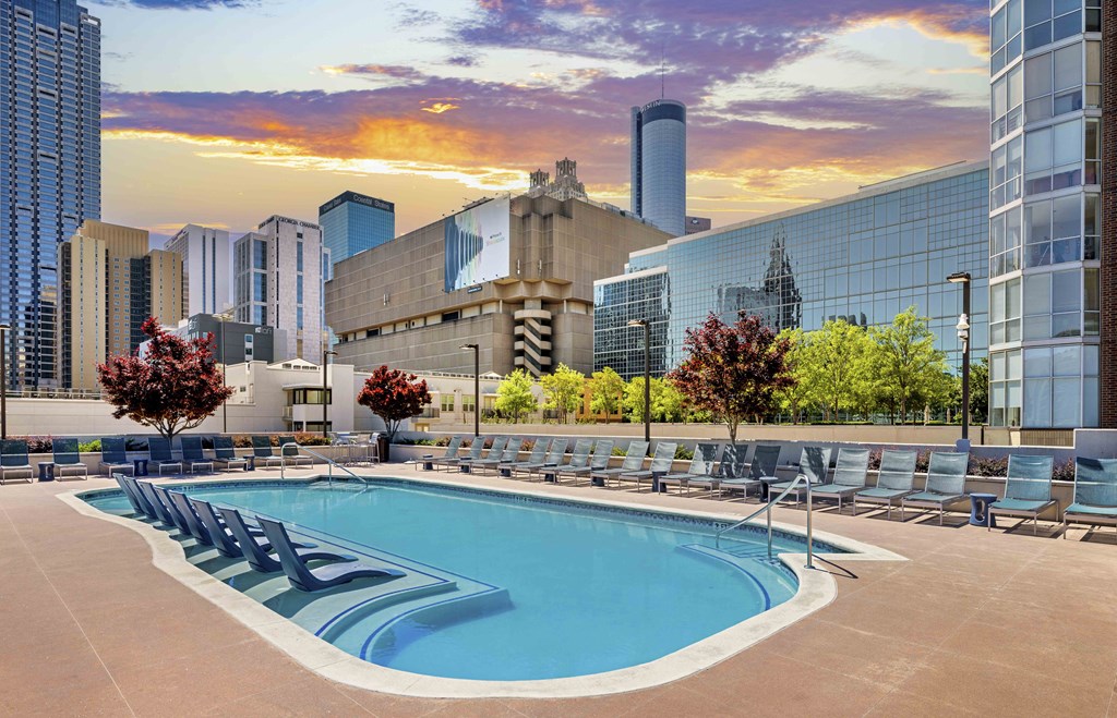a pool at a hotel with a city skyline in the background
