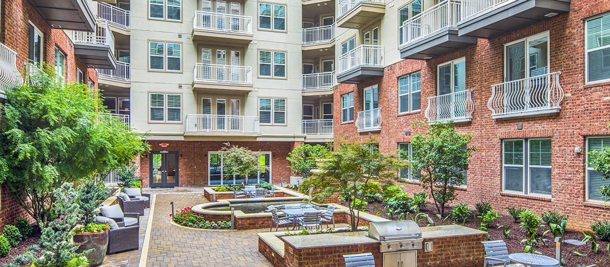 an outdoor courtyard with a fountain in front of an apartment building