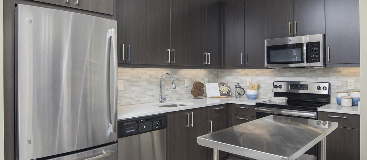 a kitchen with stainless steel appliances and black and white cabinets
