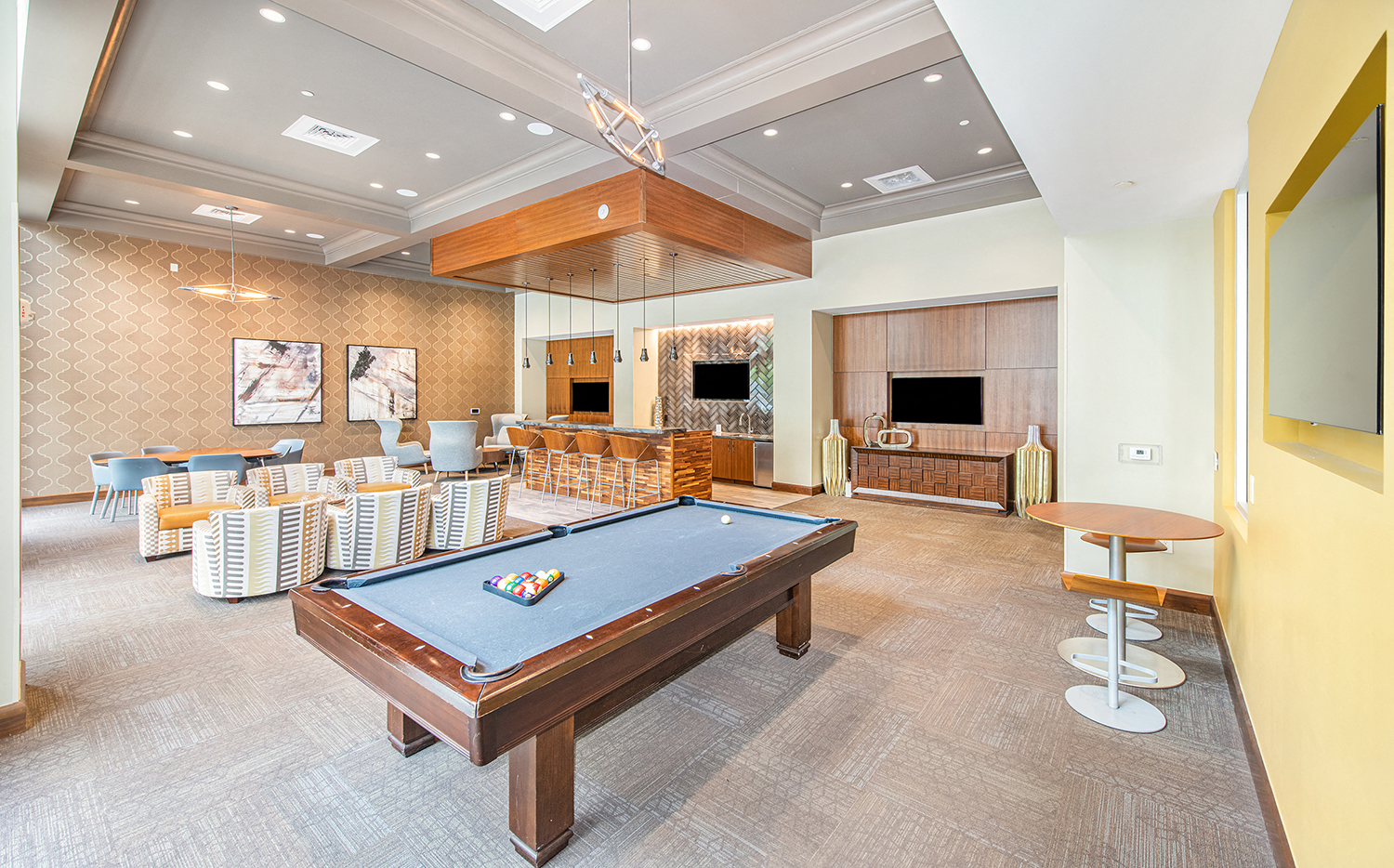 a community room with a pool table and a bar