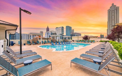 a swimming pool at a hotel with the city skyline in the background