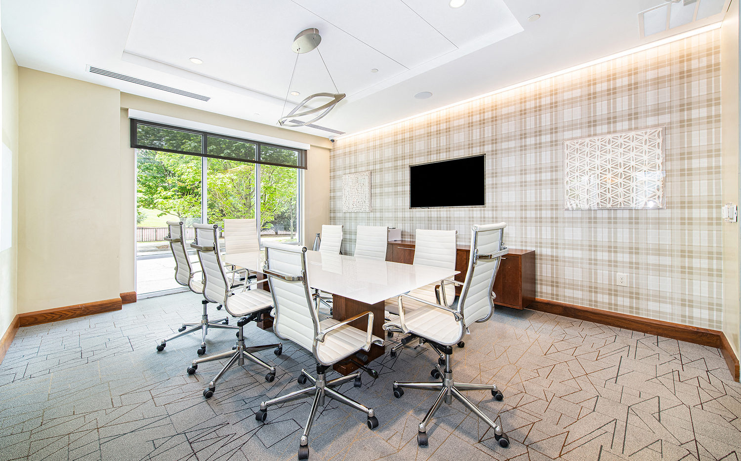 a conference room with a white table and chairs and a large window