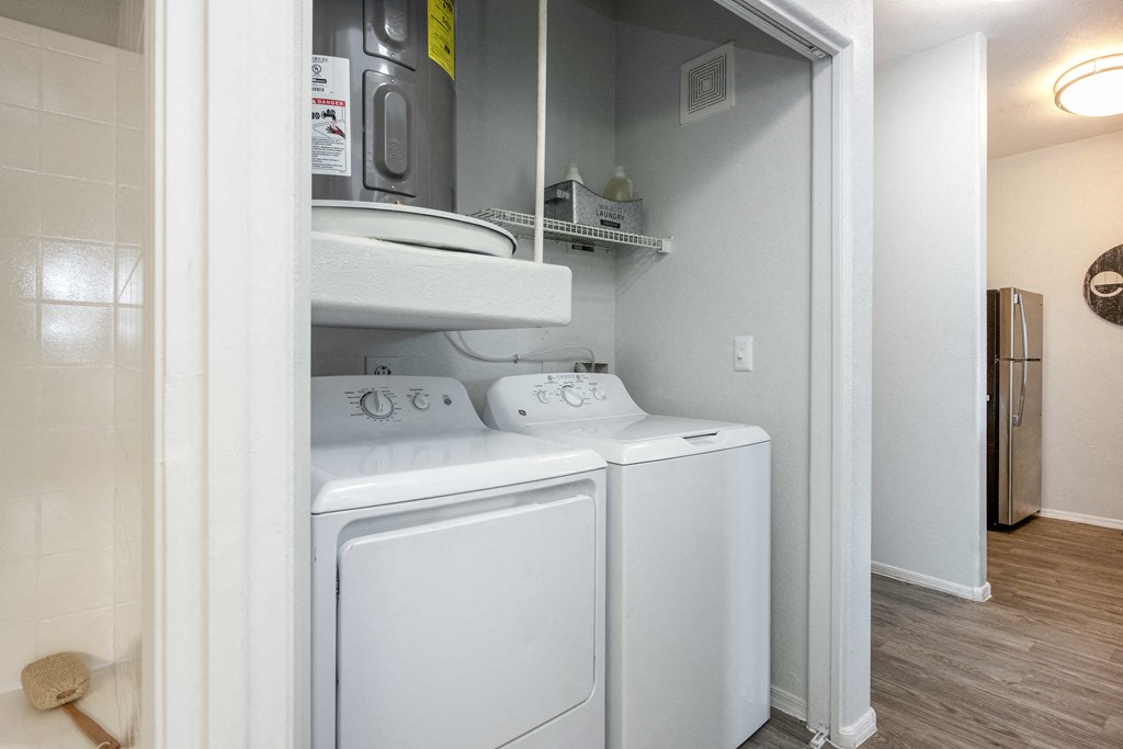 a washer and dryer in a laundry room with a door to the closet