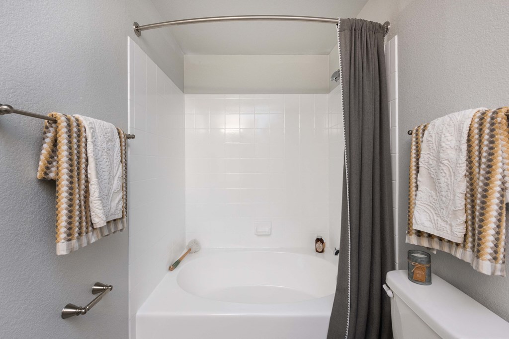 a bathroom with a bath tub and a shower with towels