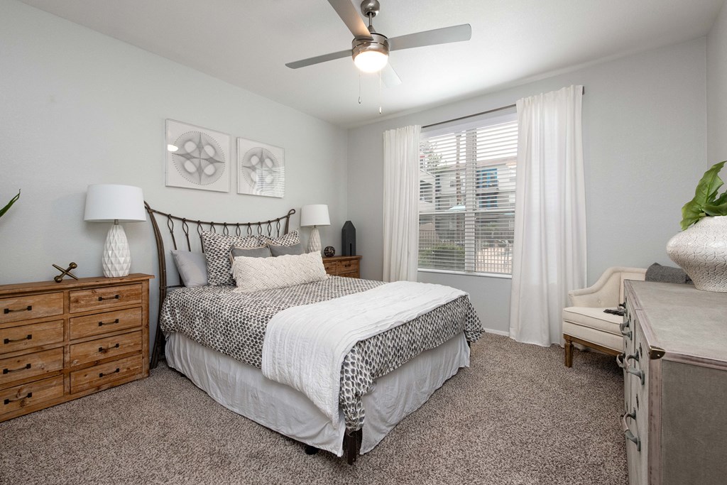 a bedroom with a bed and a ceiling fan