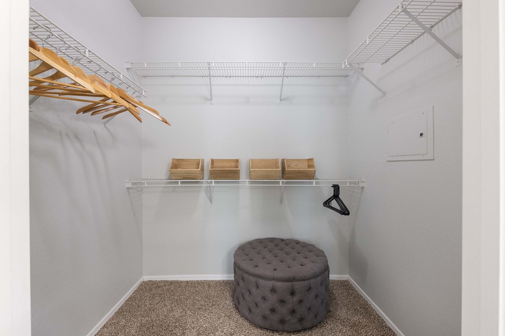an empty closet with a stool and a rack with wooden stools