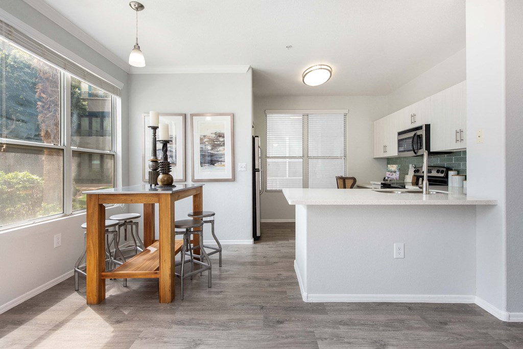 a kitchen with a large window and a bar with stools