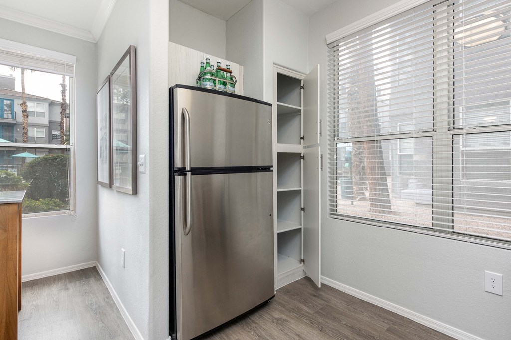 a kitchen with a stainless steel refrigerator next to a window