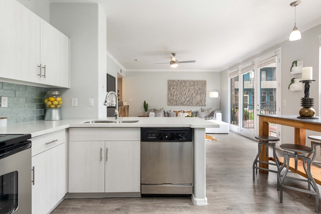 a kitchen with white cabinets and a stainless steel dishwasher