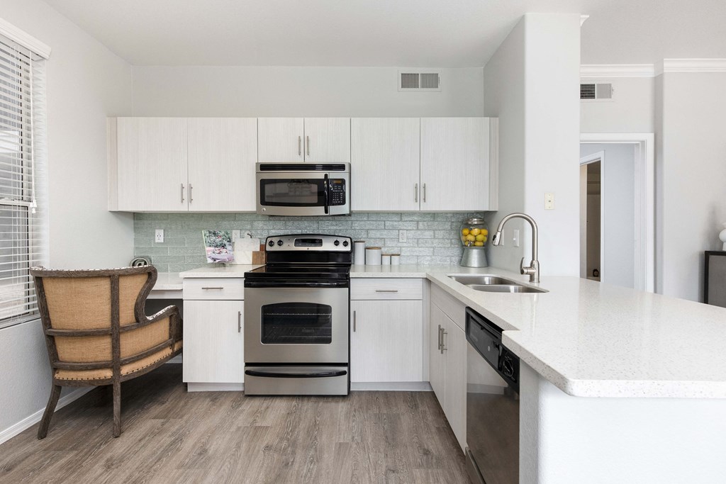 a kitchen with white cabinets and stainless steel appliances