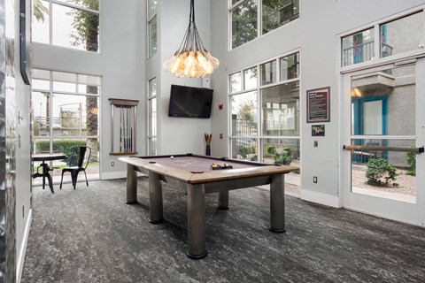 a game room with a pool table and a tv
