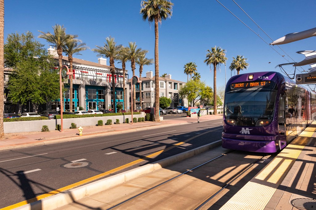 a purple bus is stopped at a bus stop on a street