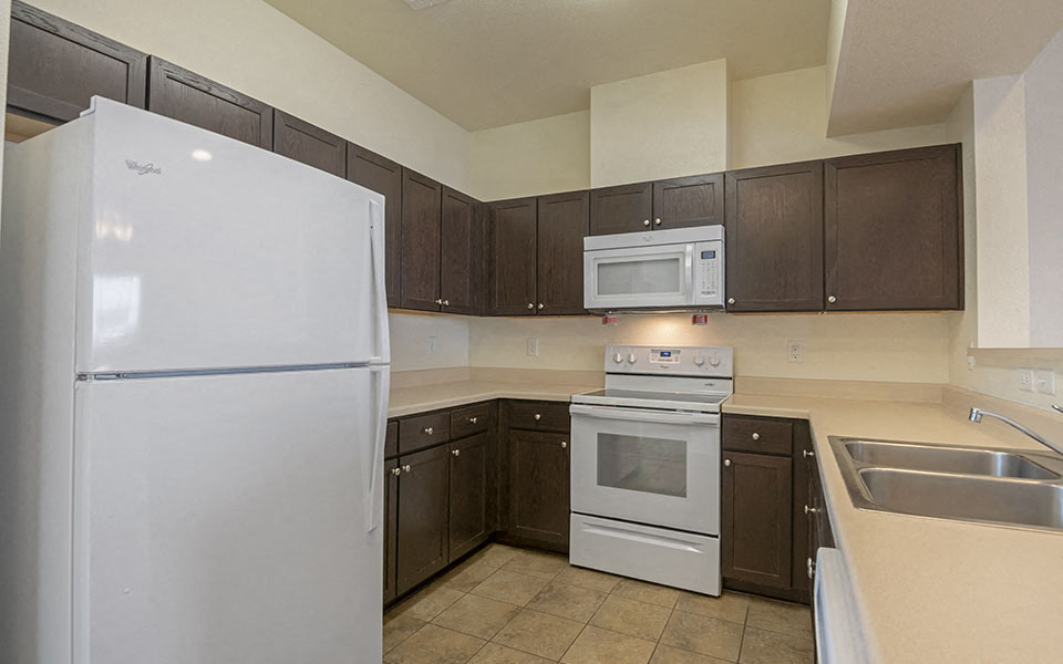 a kitchen with white appliances and brown cabinets